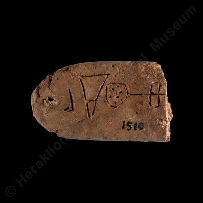 Long clay tablet with rounded ends with Linear A inscription